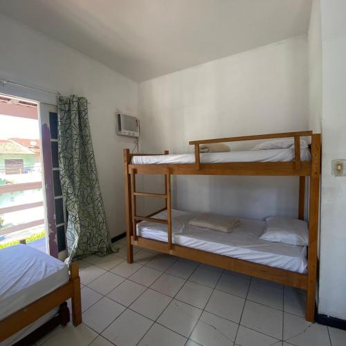 two bunk beds in a room with a window at Hostel ABC in Angra dos Reis