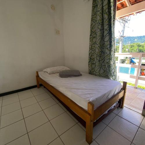 a small bed in a room with a window at Hostel ABC in Angra dos Reis
