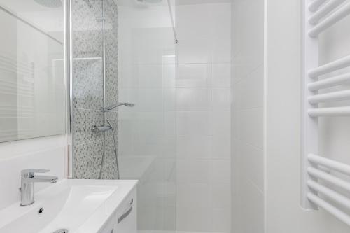 une salle de bain blanche avec une douche et un lavabo dans l'établissement Fée Morgane, à Brest