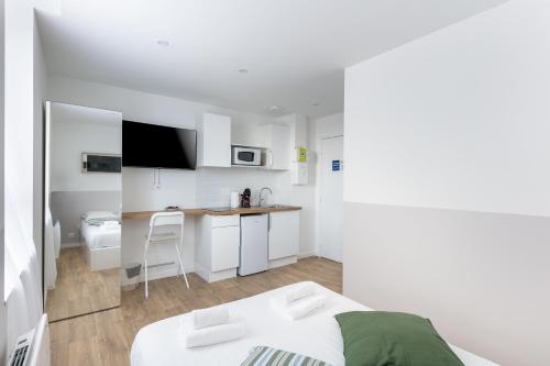 Cette chambre blanche dispose d'un lit et d'une cuisine. dans l'établissement Fée Morgane, à Brest