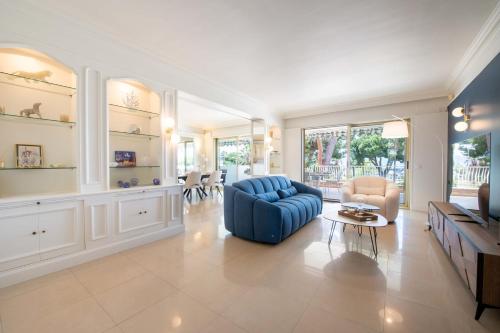 un grand salon avec un canapé bleu et des chaises dans l'établissement 3-Br Apartment with Sea View & Terrace La Croisette, à Cannes