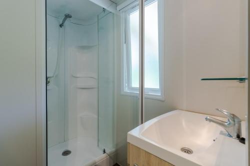 une salle de bain avec une douche en verre et un lavabo dans l'établissement Mobilhome 6 personnes climatisé, à Saint-Martial-de-Nabirat