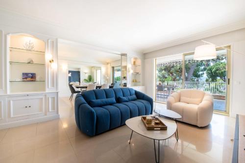 un salon avec un canapé bleu et deux chaises dans l'établissement 3-Br Apartment with Sea View & Terrace La Croisette, à Cannes