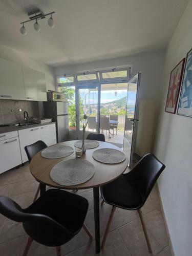 a kitchen and dining room with a table and chairs at Vila Mozara in Slano
