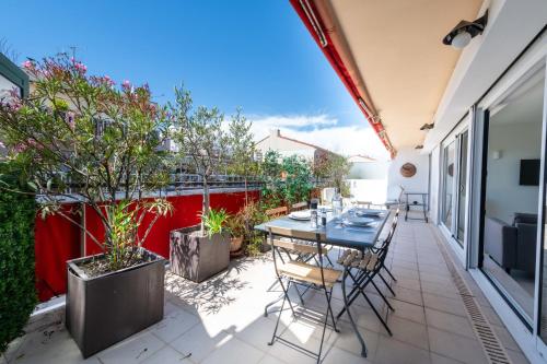 un patio avec une table, des chaises et des plantes dans l'établissement 1-Br Apartment Top Floor Pointe Croisette, à Cannes