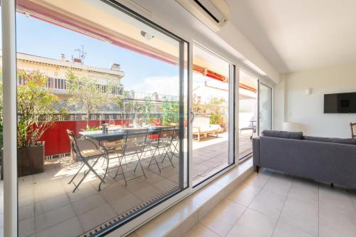 - un salon avec des portes coulissantes en verre, une table et des chaises dans l'établissement 1-Br Apartment Top Floor Pointe Croisette, à Cannes