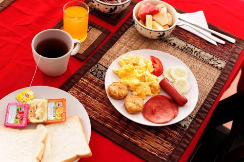 a table with two plates of breakfast food and a cup of coffee at Lotus Friendly Hotel in Chaweng