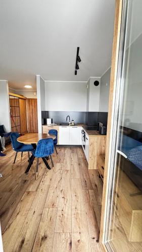 a kitchen with a table and blue chairs in a room at Apartament Pogodny 2 Z PARKINGIEM PODZIEMNYM in Chojnice