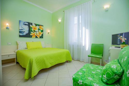 ein Schlafzimmer mit einem grünen Bett und einem Stuhl in der Unterkunft Affittacamere Oasi di Antonella in Albinia