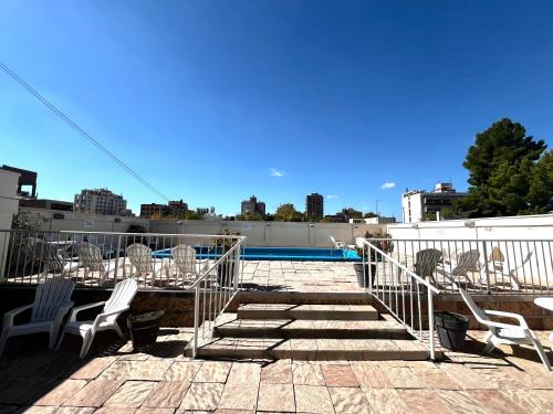 a patio with chairs and a table and a pool at Precioso departamento en la mejor ubicación de Ciudad Mendoza, con piscina in Mendoza