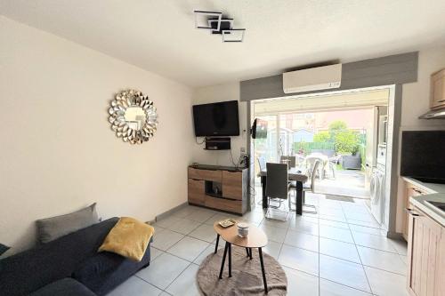 un salon avec un canapé et une table dans l'établissement EUREKA 109 - 6 People - Pool and Garden - Near Naturist Village and Beaches, au Cap d'Agde