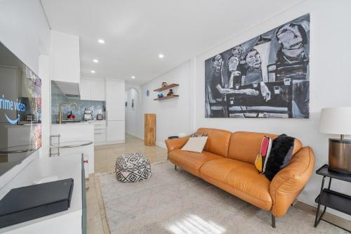 a living room with a couch and a kitchen at Gallery on Kent - Prime Location in Sydney