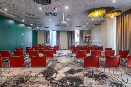 a room with red chairs and a green wall at ibis Bucharest Politehnica in Bucharest
