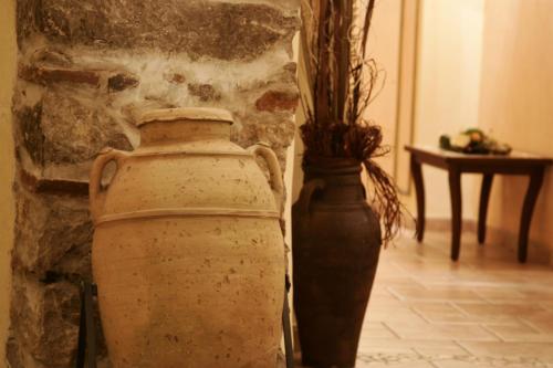 two vases sitting next to a wall with a table at Hotel Villa Torre Antica in Atena Lucana