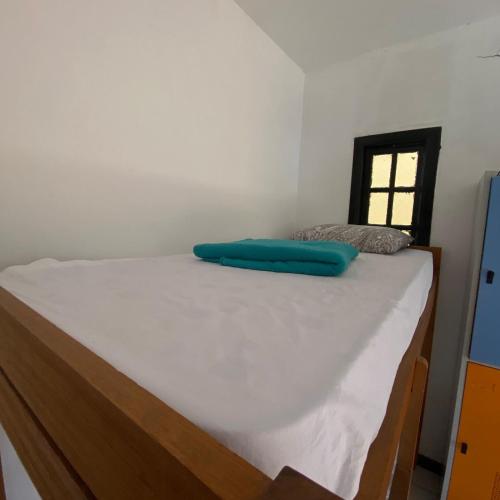 a bed with a blue pillow on top of it at Hostel ABC in Angra dos Reis