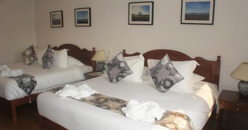 a bedroom with two beds with white sheets and pillows at Heeren Straits Hotel in Melaka