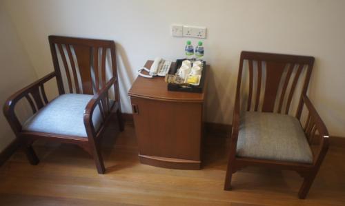 a desk with two chairs and a telephone in a room at Heeren Straits Hotel in Melaka