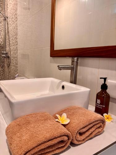 a bathroom sink with towels on a counter at Kampana Homestay in Uluwatu