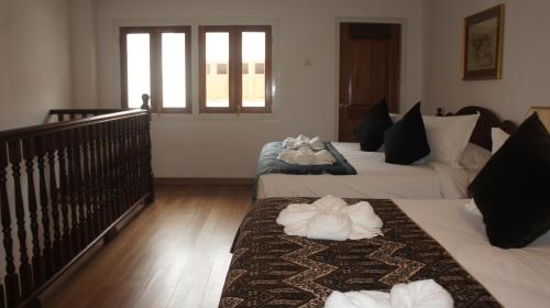 a hotel room with two beds with towels on them at Heeren Straits Hotel in Melaka