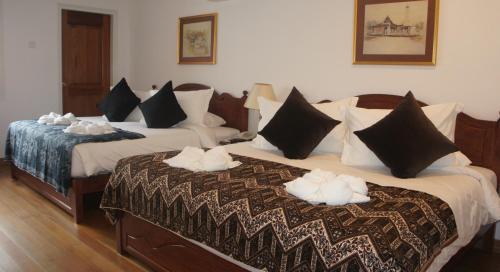 two beds in a hotel room with towels on them at Heeren Straits Hotel in Melaka