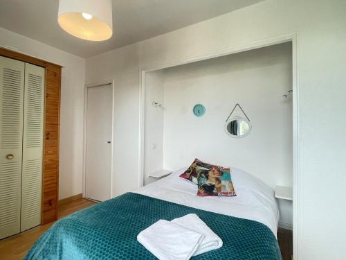 une chambre avec un lit avec une couverture verte dans l'établissement Le Rétro - Nouvelle décoration, à Albi