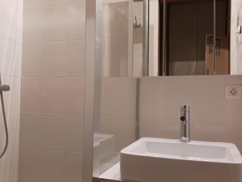 une salle de bain blanche avec un lavabo et un miroir dans l'établissement Studio cosy 4 personnes proche commerces et pistes, animaux acceptés - FR-1-411-641, à Peisey-Nancroix