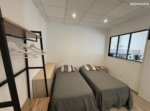 une chambre avec deux lits et une fenêtre dans l'établissement La Fontaine, à Neussargues en Pinatelle