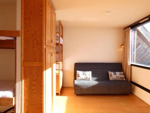 une chambre avec un canapé noir dans une chambre avec une fenêtre dans l'établissement Studio 4 pers. avec balcon au sud, à Piau-Engaly, cuisine équipée et accès direct aux pistes - FR-1-457-155, à Aragnouet