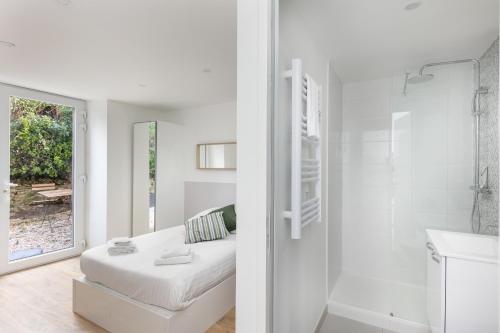 La salle de bains blanche est pourvue d'un lit et d'une douche. dans l'établissement L'Ankou, à Brest