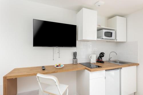 une cuisine avec un comptoir avec une télévision au mur dans l'établissement L'Ankou, à Brest