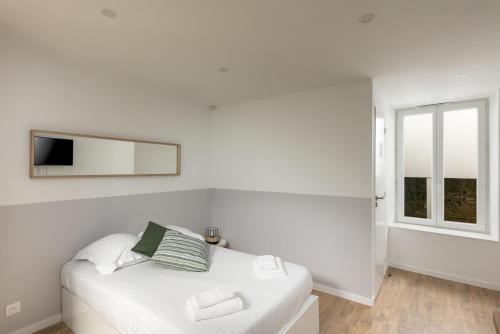 Cette chambre blanche dispose d'un canapé blanc et d'une fenêtre. dans l'établissement L'Ankou, à Brest