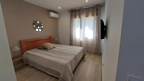 a small bedroom with a bed and a window at Villa in Salgados Golf - Albufeira in Guia