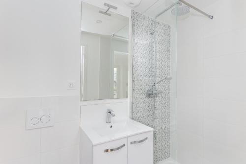 une salle de bain blanche avec un lavabo et une douche dans l'établissement Korrigan, à Brest
