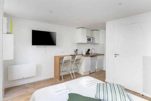 Cette chambre blanche dispose d'un lit et d'une cuisine. dans l'établissement Korrigan, à Brest