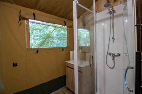 un baño con ducha y lavabo en Tente Lodge 8 personnes, en Saint-Martial-de-Nabirat