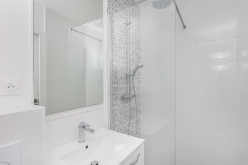 une salle de bain blanche avec une douche et un lavabo dans l'établissement Merzhin, à Brest