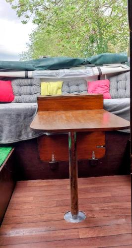 une table posée sur une terrasse avec deux lits dans l'établissement Studio bateau au Somail, à Saint-Nazaire-dʼAude