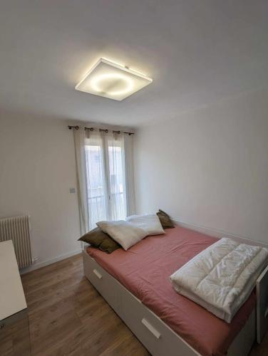 un lit dans une chambre avec une grande fenêtre dans l'établissement Chez Clara et Paul - Centre Ville Narbonne, à Narbonne