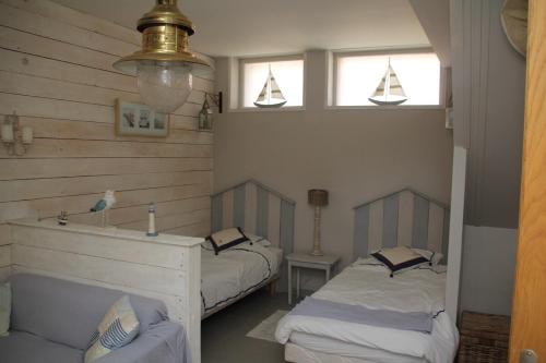 a room with two beds and two windows at Studio littoral à Wavrechain in Wavrechain-sous-Faulx