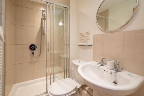 a bathroom with a toilet and a sink and a shower at 67 Pebble Cottage in Aldeburgh