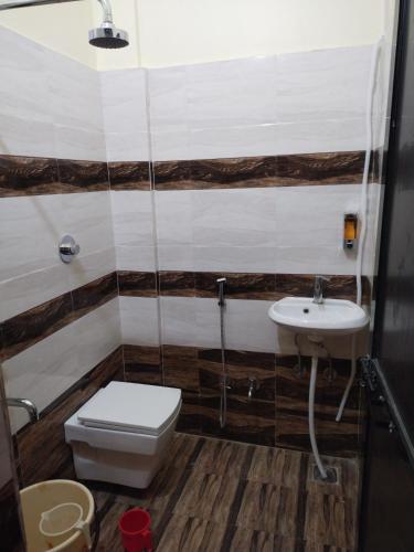 a bathroom with a toilet and a sink at Hotel Silver Park and Restaurant in Bilāspur