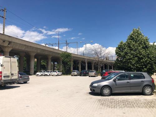 a parking lot with cars parked in front of a bridge at VD Apartment 2 ,only 5 min from main Bus Station in Skopje