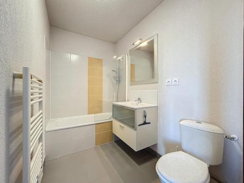 une salle de bain blanche avec des toilettes et un lavabo dans l'établissement 3326-Appartement 4 couchages avec une piscine, à Argelès-sur-Mer