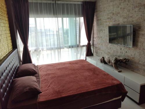 a bedroom with a bed with a large window at The Gallery Condominium B in Jomtien Beach