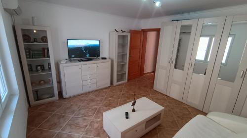 a living room with a tv and a white couch at Apartments Abramovic 2 in Sutomore