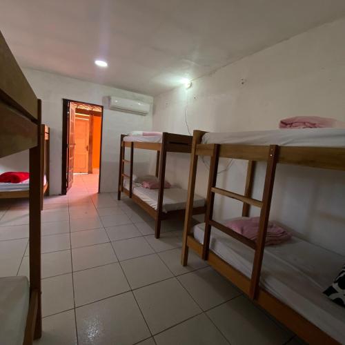 a room with three bunk beds and a hallway at Hostel ABC in Angra dos Reis