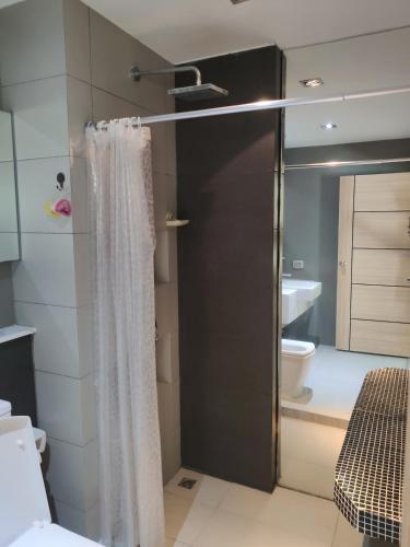 a bathroom with a shower curtain and a toilet at The Gallery Condominium B in Jomtien Beach