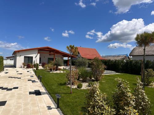 a house with a yard with trees and plants at Vila Alma in Ilganii de Jos