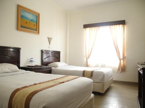 Postel nebo postele na pokoji v ubytování Hotel Bukit Serelo
