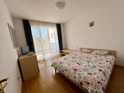 a bedroom with a bed and a television and a window at MIRA Apartment SEA PARADISE in Kavarna